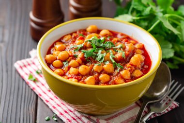 Baharatlı nohut koyu ahşap masa üzerinde kase Chana masala köri. Geleneksel Hint yemeği. Seçici odak.
