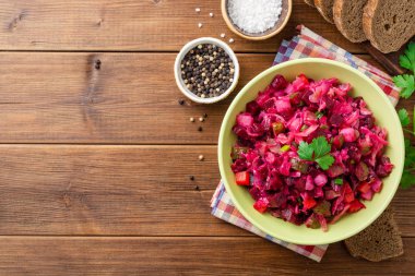 Geleneksel Rus salata salata ile haşlanmış sebzeler, turşu salatalık ve lahana turşusu ahşap masada kase. Üst görünüm. Boşluk Kopyala.