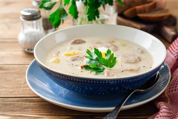 Traditional polish soup Zurek on wooden table. Selective focus.