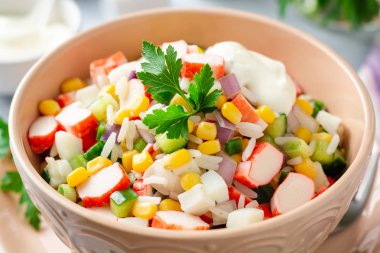 Yengeç çubuklu salata, tatlı mısır, salatalık, haşlanmış yumurta, soğan ve pirinç. Rus mutfağı. Seçici odak.