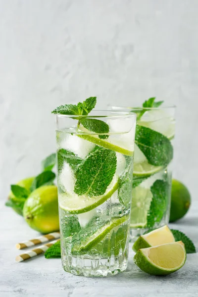 Beton arka planda cam kireç ve nane ile taze Mojito kokteyl. Soğuk serinletici içecek. Seçici odak.