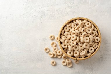 Beton arka planda kasede tam tahıl gevreği halkaları. Sağlıklı kahvaltı. Üst Manzara. Boşluğu kopyala.