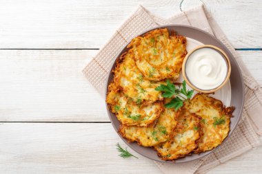 Patatesli gözleme, latke ya da beyaz ahşap masada ekşi kremalı Draniki. Üst Manzara. Boşluğu kopyala.