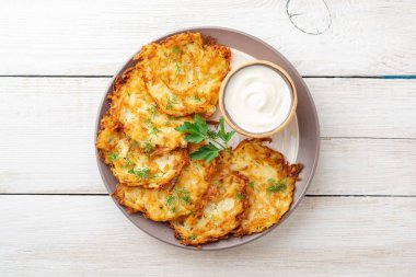 Patatesli gözleme, latke ya da beyaz ahşap masada ekşi kremalı Draniki. Üst Manzara. Boşluğu kopyala.