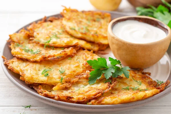 Patatesli gözleme, latke ya da beyaz ahşap masada ekşi kremalı Draniki. Seçici odak.