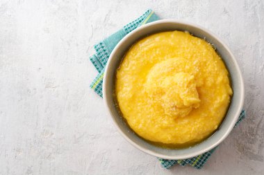 Beton arka planda tereyağlı ve parmesan peynirli Polenta. Üst Manzara. Boşluğu kopyala.