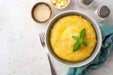 Beton arka planda tereyağlı ve parmesan peynirli Polenta. Üst Manzara. Boşluğu kopyala.