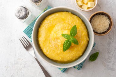 Beton arka planda tereyağlı ve parmesan peynirli Polenta. Üst görünüm.
