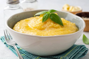 Beton arka planda tereyağlı ve parmesan peynirli Polenta. Seçici odak.
