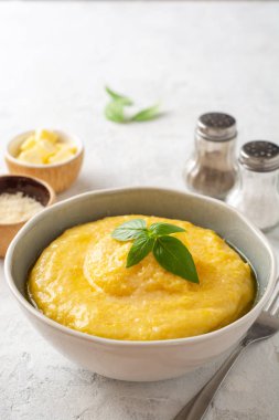 Beton arka planda tereyağlı ve parmesan peynirli Polenta. Seçici odak.