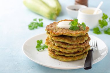 Taze maydanozlu kabaklı börek ve mavi beton kaplamalı ekşi krema. Seçici odak.