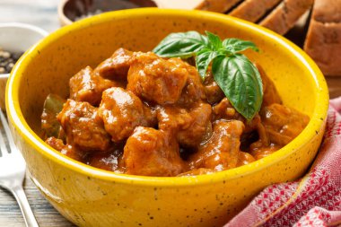 Kırsal ahşap arka planda seramik kasede et güveci. Seçici odak.