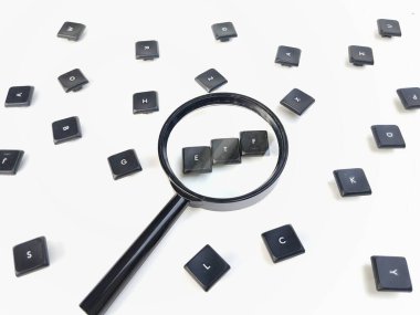 Beyaz arkaplanda izole edilmiş bir büyüteçle görüntülenen ETF rastgele klavye tuşları. Finansal veya yatırım kavramları