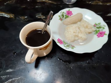 Bir fincan kahve ve hindistan cevizi sütü soslu bir tabak yapışkan pirinç.