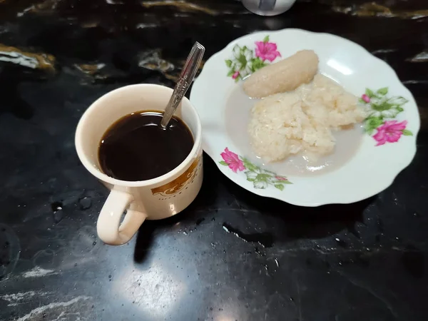 Bir fincan kahve ve hindistan cevizi sütü soslu bir tabak yapışkan pirinç.