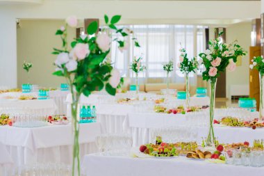 Tabloları şölende hizmet. Tatlılar, meyve ve hamur işleri büfe üzerinde. Cam ve maden suyu şişeleri. Bir sürahi içinde gül. Catering.