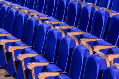 Mavi peluş sandalye ahşap kol dayama salonu ile. Boş tiyatro salonunda.