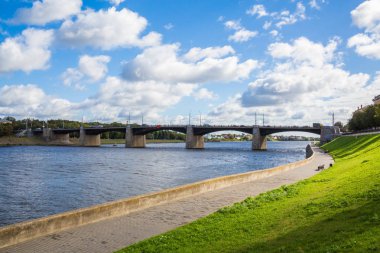 Yeni Volga Köprüsü ve city quay Tver, Rusya. Pitoresk nehir manzara. Mavi gökyüzünde bulutlar. Yeşil çimenlerin üzerinde çim. Yaz veya sonbahar güneşli gün.
