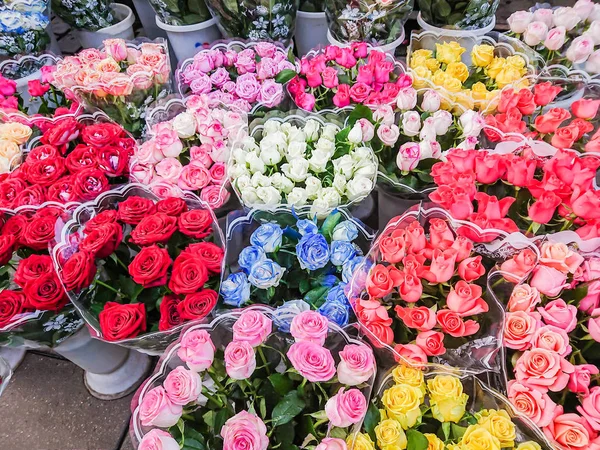 Bouquets of different varieties of roses are sold in the street market. Multi-colored flowers.