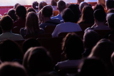 Seyirci bir sinemada bir tiyatro performans, ya da bir konserde. Arkadan ateş. Seyirciler salonda. İnsan siluetleri.