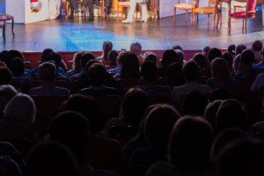 Seyirci bir sinemada bir tiyatro performans, ya da bir konserde. Arkadan ateş. Seyirciler salonda. İnsan siluetleri.