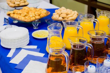 Portakal ve elma suları sürahilere, büfe üzerinde tatlı hamur işleri.