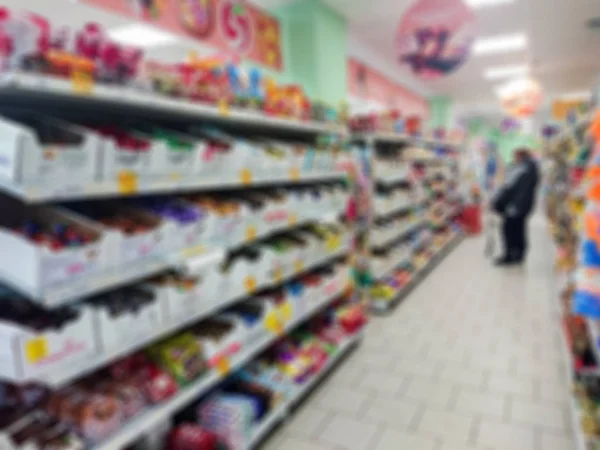 Blurred abstract image. Goods on the shelf of a grocery store. Candy and other confectionery.