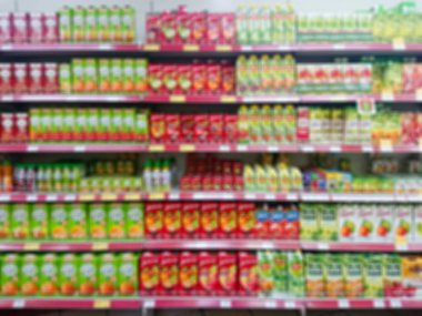 Bulanık soyut resim. Mallar bir bakkal rafta. Meyve suları ve nektarı karton kutular içinde.