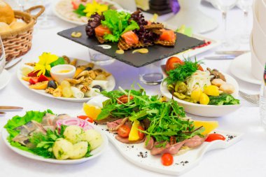 Büfe üzerinde çeşitli soğuk mezeler: deniz ürünleri, sebze, et, lezzetleri.