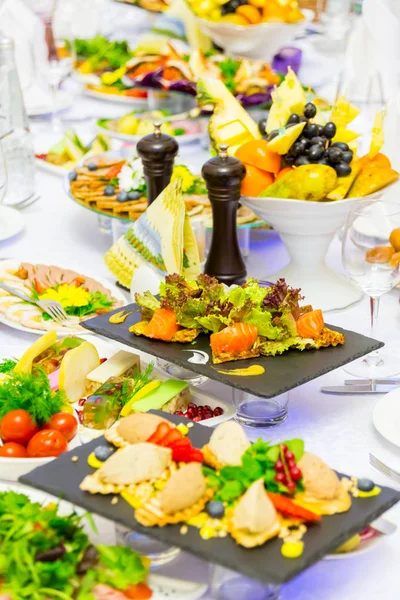 Delicacies, snacks and fruit on the festive table in the restaurant. Celebration. Catering. Banquet table.