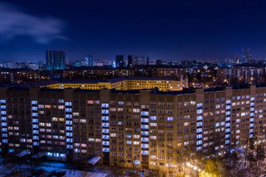 Akşam veya gece şehir manzarası. Işıklar apartmanlar Windows.