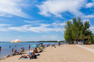Saratov / Rusya - 6 Temmuz 2018: insanlar sahilde nehirde yüzmek. Güneşli yaz günü. Pitoresk bulutlar gökyüzünde. Nehir manzara.
