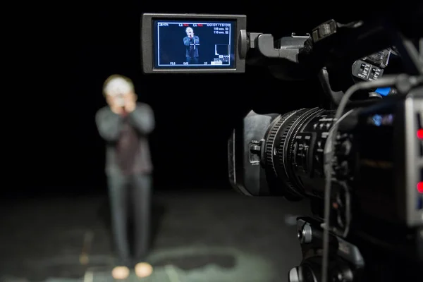 Actor in front of the camera. LCD display on the camcorder. Filming in the interior.