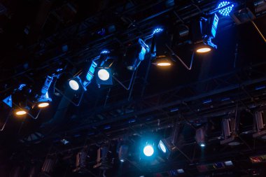 Tiyatro ya da konser salonunun aydınlatma donanımları Sahne Alanı'nda. Projektörler gelen ışık ışınları.