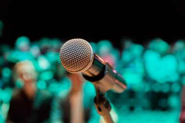 Kablosuz mikrofon stand. Arka plan bulanık. İnsanlar izleyici. Sahne Alanı'nda tiyatro ya da konser salonunda göster.