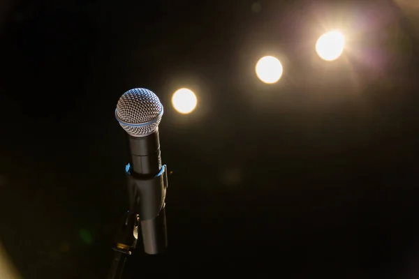Wireless microphone on the stand on the background of spotlights on the stage.