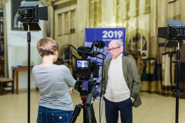 La fille interroge l'homme. Tournage vidéo à l'intérieur. LCD — Photo