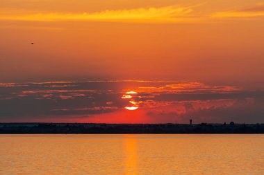 Temmuz 'da Rusya' da Volga nehrinde gün batımı. Gökyüzünde turuncu güneş. Resimli doğa. Yaz akşamı. Nehir gezisi