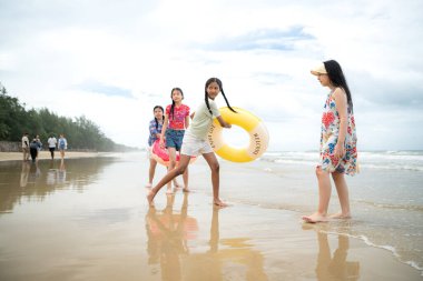 Happy children playing together in the sea, enjoying a fun summer day at the beach with laughter and friendship