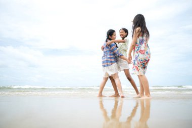 Happy children playing together in the sea, enjoying a fun summer day at the beach with laughter and friendship