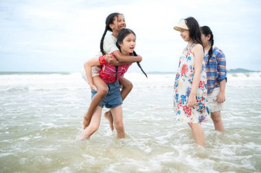 Happy children playing together in the sea, enjoying a fun summer day at the beach with laughter and friendship