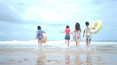 Happy children playing together in the sea, enjoying a fun summer day at the beach with laughter and friendship
