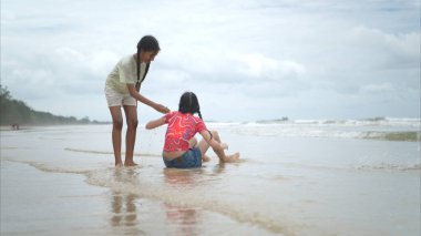 Happy children playing together in the sea, enjoying a fun summer day at the beach with laughter and friendship