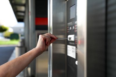 Elle, modern teknoloji ve kentsel kolaylığı yansıtan lüks ödeme terminaline kart sokuyor. Temassız ödeme çözümlerini resmetmek için mükemmel.