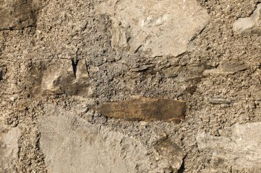 Düzensiz kayalar ve gri beton harçla inşa edilmiş sert taş duvar, doğal dokuyu ve engebeli tasarımı vurgulayan arka planlar için idealdir..