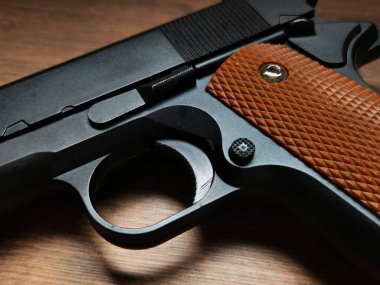 Ahşap kabzalı ve siyah kaplamalı ateşli bir silahın yakın çekimi. Sadece hava yumuşaklığında bir kopya olmasına rağmen fotoğraf, güç ve tehlike uyandırırken silahların güzelliğini vurguluyor..