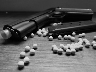 A black pistol in the foreground with a magazine beside it. Though just an airsoft replica, the photo showcases the weapon's beauty while conveying power and danger.