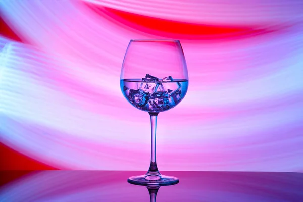 Ein Glas Mit Einem Getränk Und Eiswürfeln Auf Rotem Hintergrund — Stockfoto