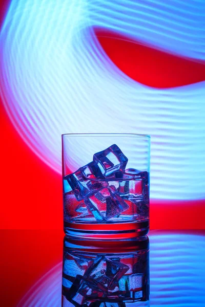Sebuah Gelas Dengan Minuman Dan Batu Latar Belakang Merah Dengan — Stok Foto