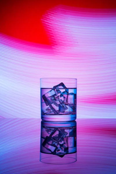 Copo Com Uma Bebida Cubos Gelo Fundo Vermelho Com Luzes — Fotografia de Stock